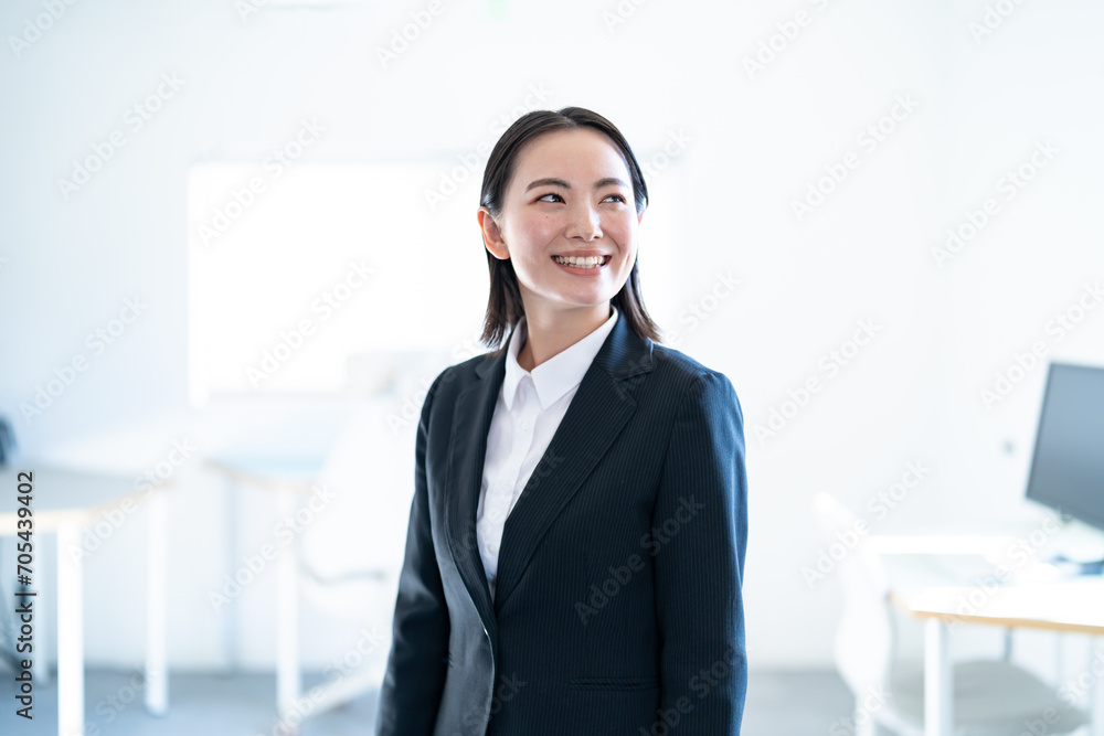 オフィスにいる若手のスーツを着た日本人女性 オフィスにいる若手のスーツを着た日本人女性