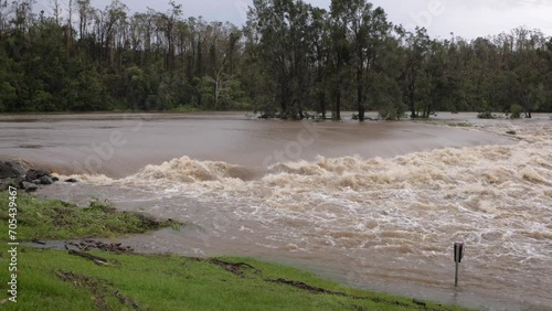 Coomera, Gold Coast, 2 January 2024 - Medium shot, Coomera River Causeway under flood waters from the 2024 Storms in January. photo