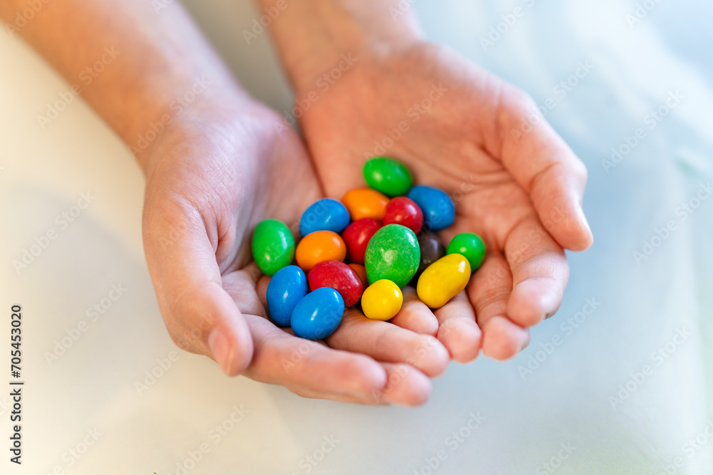 Amazed sweet-tooth. Beautiful child girl holding colorful chocolate drops Amazed sweet-tooth. Beautiful child girl holding colorful chocolate drops