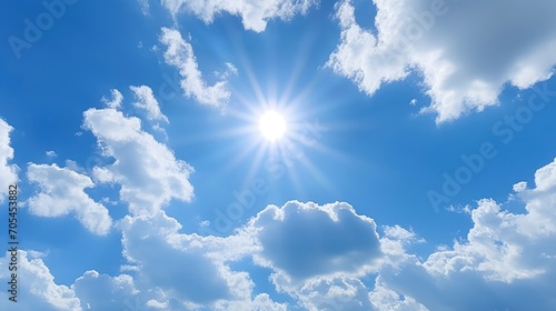 Sun with rays and glare clear blue sky and clouds Sunshine in a blue sky with white cumulus clouds in bright weather photo