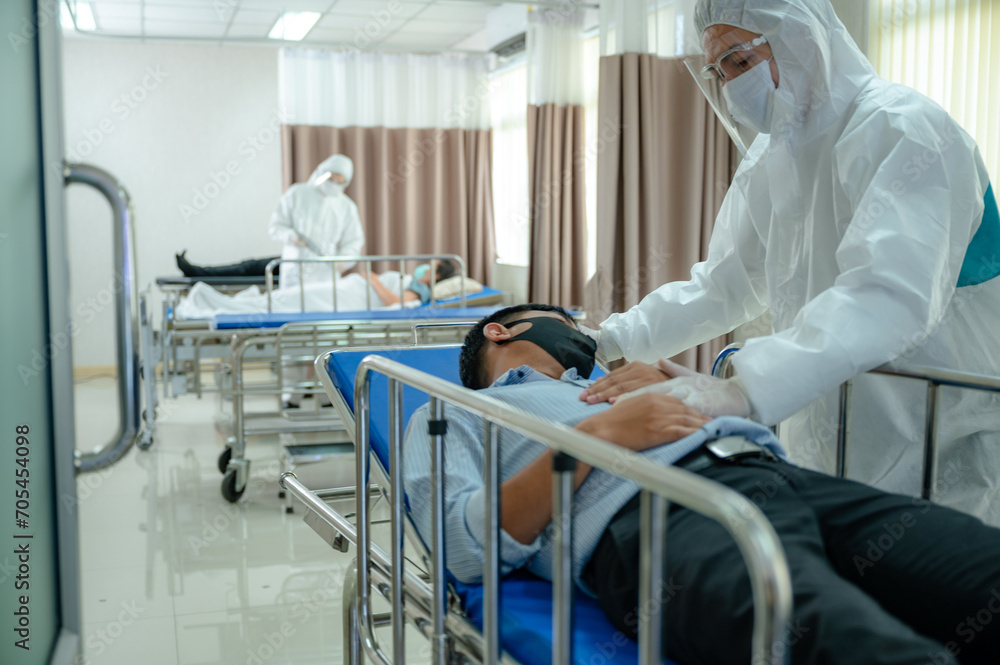 Doctor wearing face shield and PPE suit new normal working to checking a health and search data about infection, kill and treat Novel Coronavirus with patient in hospital Doctor wearing face shield and PPE suit new normal working to checking a health and search data about infection, kill and treat Novel Coronavirus with patient in hospital