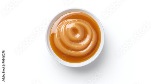 Sweet caramel sauce in a white plate isolated on white background.