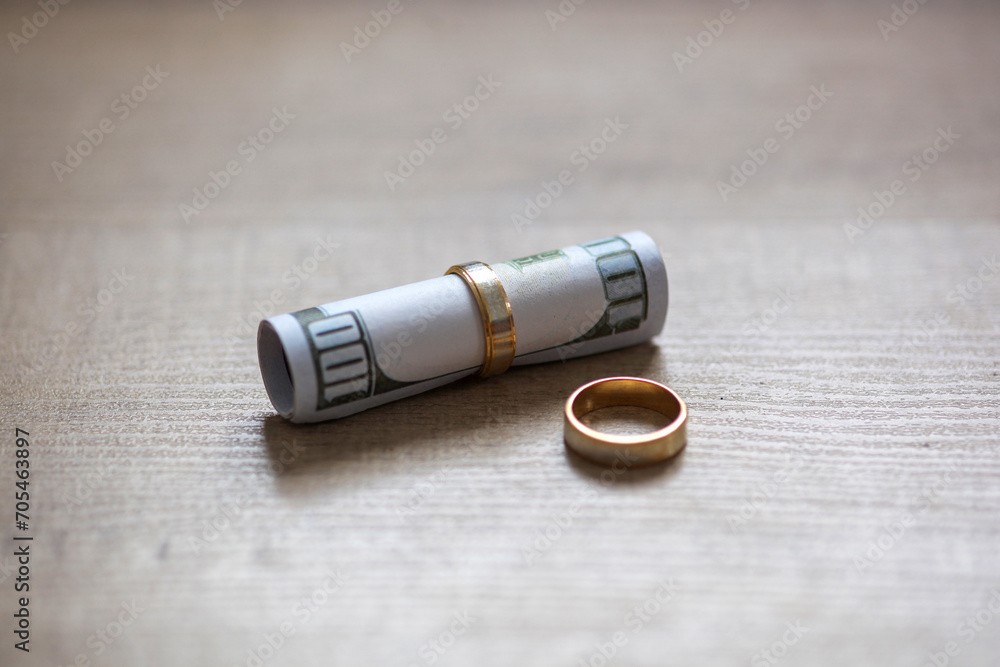 One hundred dollar bill in a gold wedding ring One hundred dollar bill in a gold wedding ring