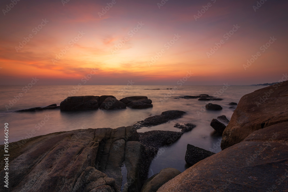 Beautiful scenery of sunset and rocks at Lan Hin Khao Beach in Rayong province, Thailand