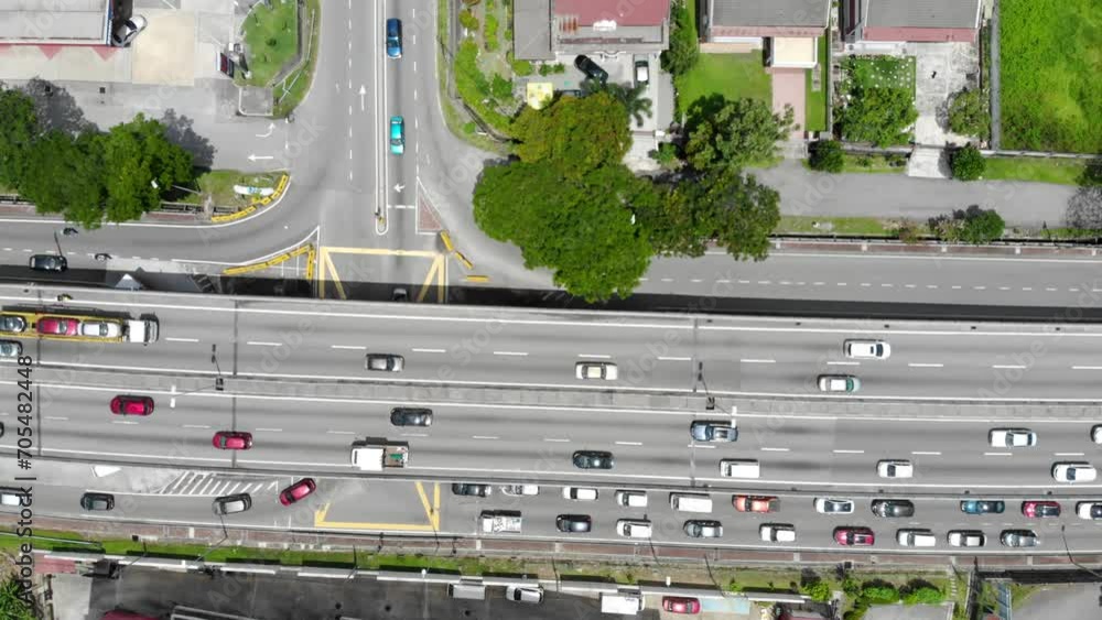 Aerial view of a busy road nearby greenery and modern houses in Malaysia Aerial view of a busy road nearby greenery and modern houses in Malaysia