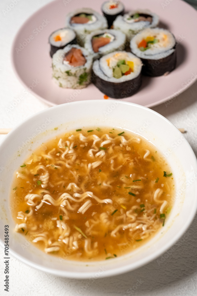 Chop sticks, mushrooms, noodle ramen, California rolls and Philadelphia rolls on a small plate on a pink background
Chop sticks, mushrooms, noodle ramen, California rolls and Philadelphia rolls on a small plate on a pink background