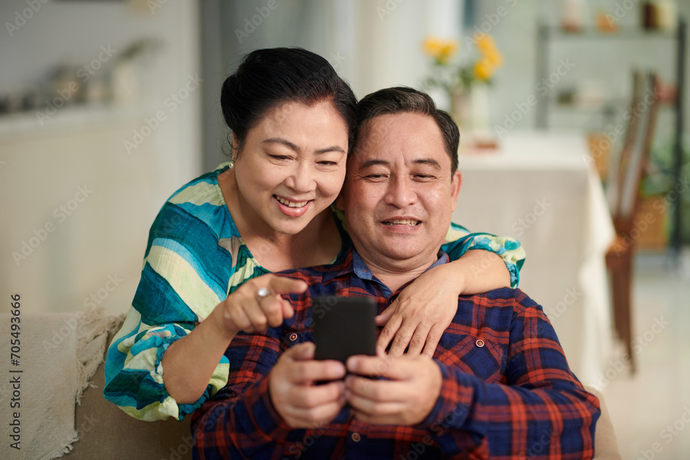 Senior couple playing game on smartphone together