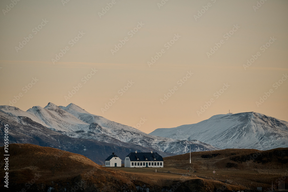 House surrounded by snowy mountains on island