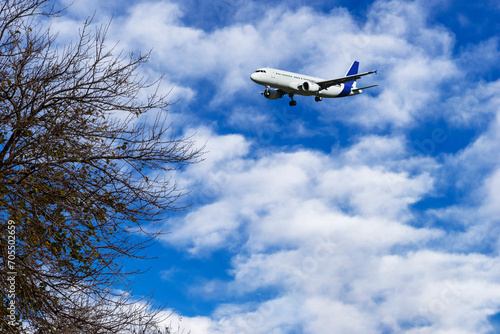A passenger plane is flying in a beautiful blue sky with white clouds.
