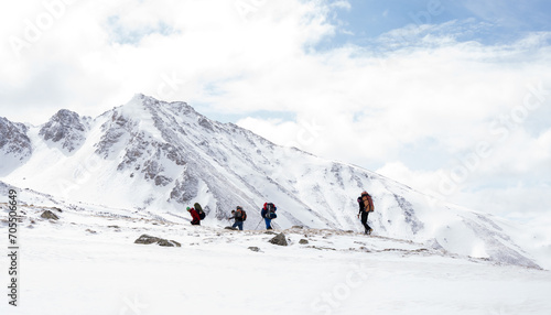 A group of people walking on the snowy mountains with their snowshoes on. Climbing the icy mountains © opolja