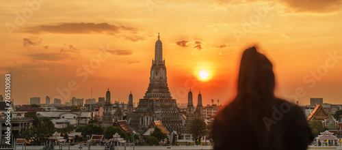 Wat Arun Temple in sunset, Tourists enjoy the view to Temple of Dawn near Chao Phraya river. Take photo from rooftop bar. Landmark and Travel destination in Bangkok, Thailand and Southeast Asia photo