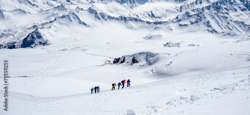 Fényképezés A group of people walking on the snowy mountains with their snowshoes on