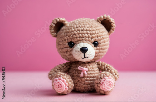 knitting teddy bear doll with simple pink background