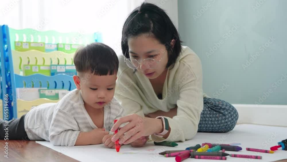 Asian Mother and little son drawing and coloring with Crayons. Woman and little child boy enjoy painting with Crayons on paper together. Asian Mother and little son drawing and coloring with Crayons. Woman and little child boy enjoy painting with Crayons on paper together.