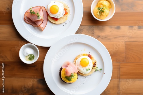 overhead shot of eggs benedict with ham, poached eggs, and english muffin