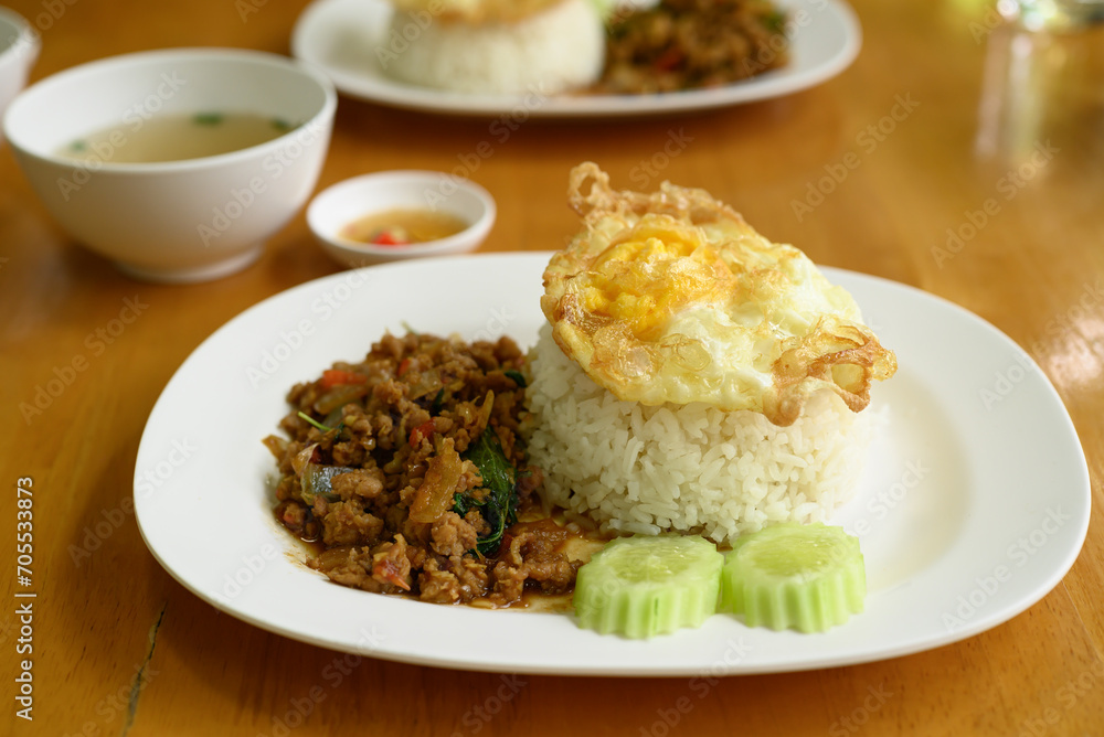 Thai stir fried basil with minced pork and fried egg eating with cooked rice, Thai food (Pad Kaprao Moo Kai Dao)