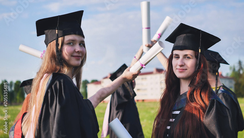 Portraits of graduating girls in black robes on the street.