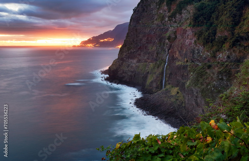 Madeira island - Dramatic sunrise over atlantic ocean with waterfall landscape from Miradouro do Veu da Noiva photo
