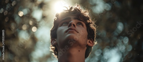 Touched by His Grace. Close-up of a beautiful young man looking up with tears in her eyes. Christian concept photo