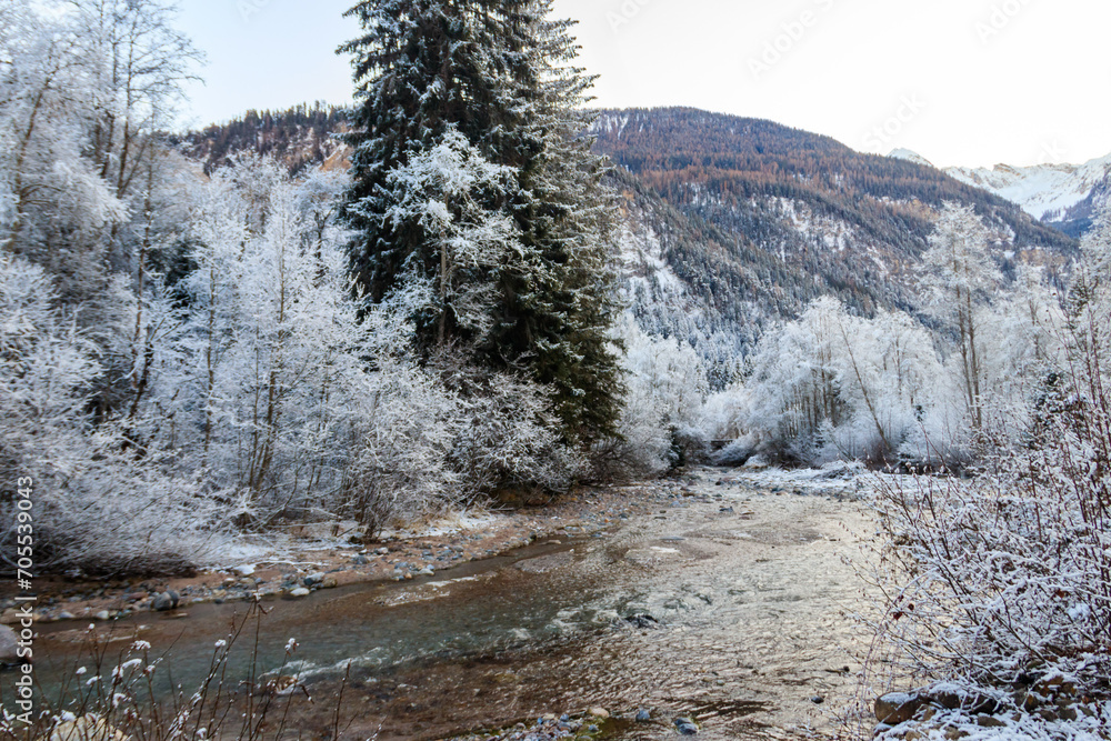 View of winter river in the Swiss Alps, Switzerland. Snowy mountain river landscape