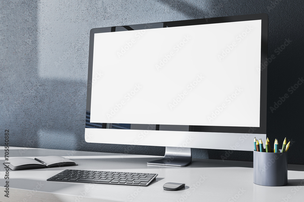 Fototapeta premium Contemporary designer office desktop with empty white mock up computer monitor, supplies and other items on gray wall background. 3D Rendering.