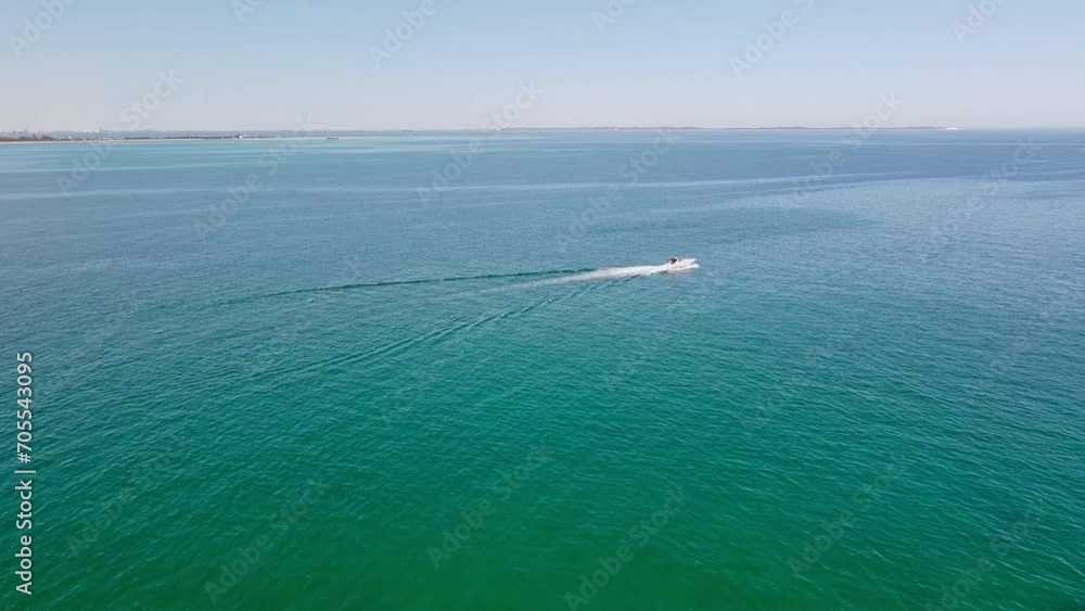Powerboat moves on ocean surface, propelled forward by powerful engines Powerboat moves on ocean surface, propelled forward by powerful engines