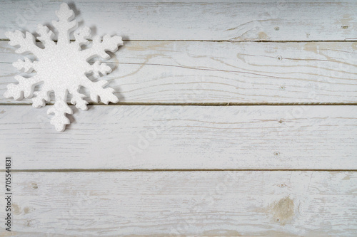 One snowflake on a white wooden background. Christmas winter flatlay with copyspace