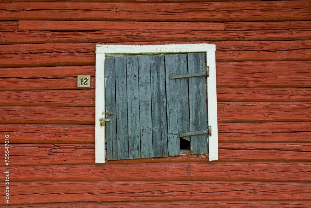 Weathered white framed black door on red wooden building. Weathered white framed black door on red wooden building.