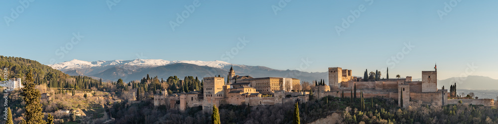 Panoramic view of the Alhambra in Granada with the Sierra Nevada mountain in the background.