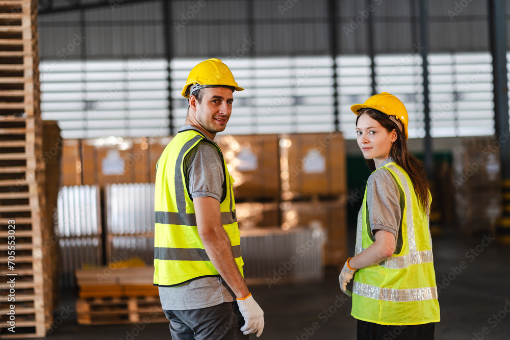 Warehouse worker logistic team wearing hard hat working in aisle between tall racks with packed goods warehouse for industry business of import, export delivery to global market, shipping management Warehouse worker logistic team wearing hard hat working in aisle between tall racks with packed goods warehouse for industry business of import, export delivery to global market, shipping management