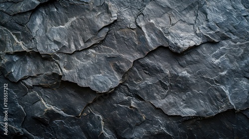 Textured black stone background created by a dark grey, rugged mountain surface with prominent cracks. Designers have plenty of space for creativity.  © Matthew