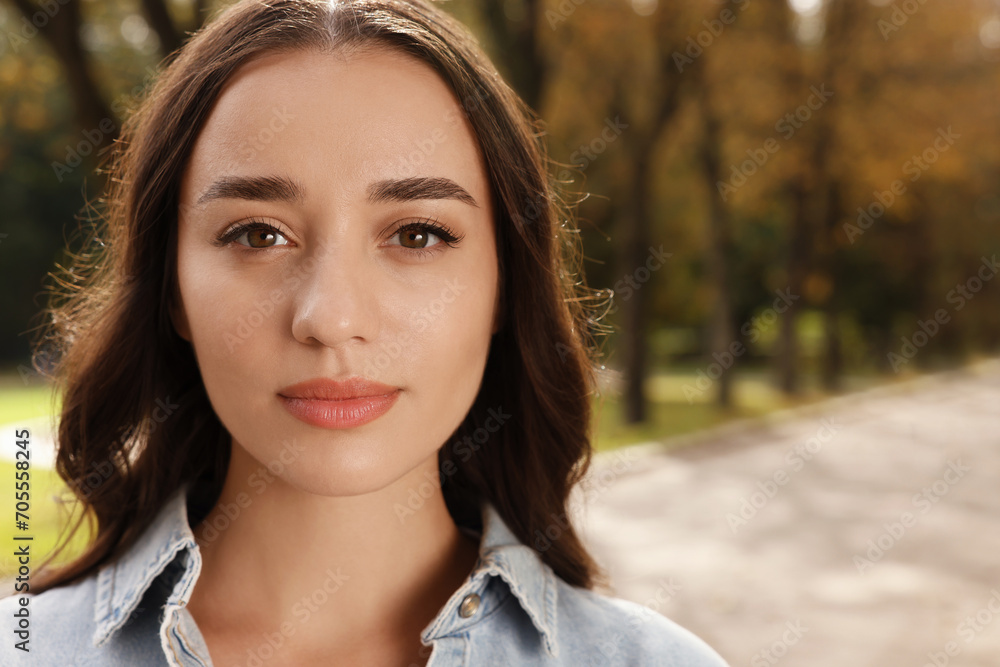 Portrait of beautiful young woman in park. Space for text Portrait of beautiful young woman in park. Space for text