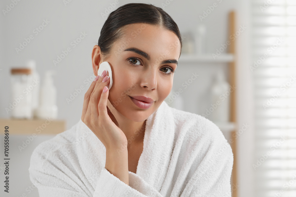 Beautiful woman removing makeup with cotton pad indoors Beautiful woman removing makeup with cotton pad indoors