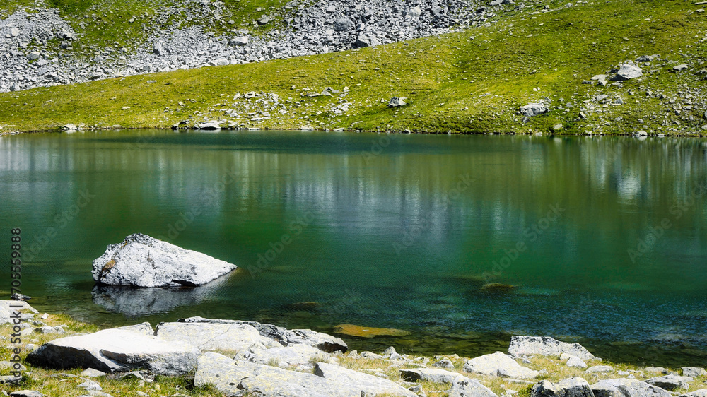 Bergsee, Stein im Wasser, Spiegelung der Felsen, Wiese und Geröll Bergsee, Stein im Wasser, Spiegelung der Felsen, Wiese und Geröll