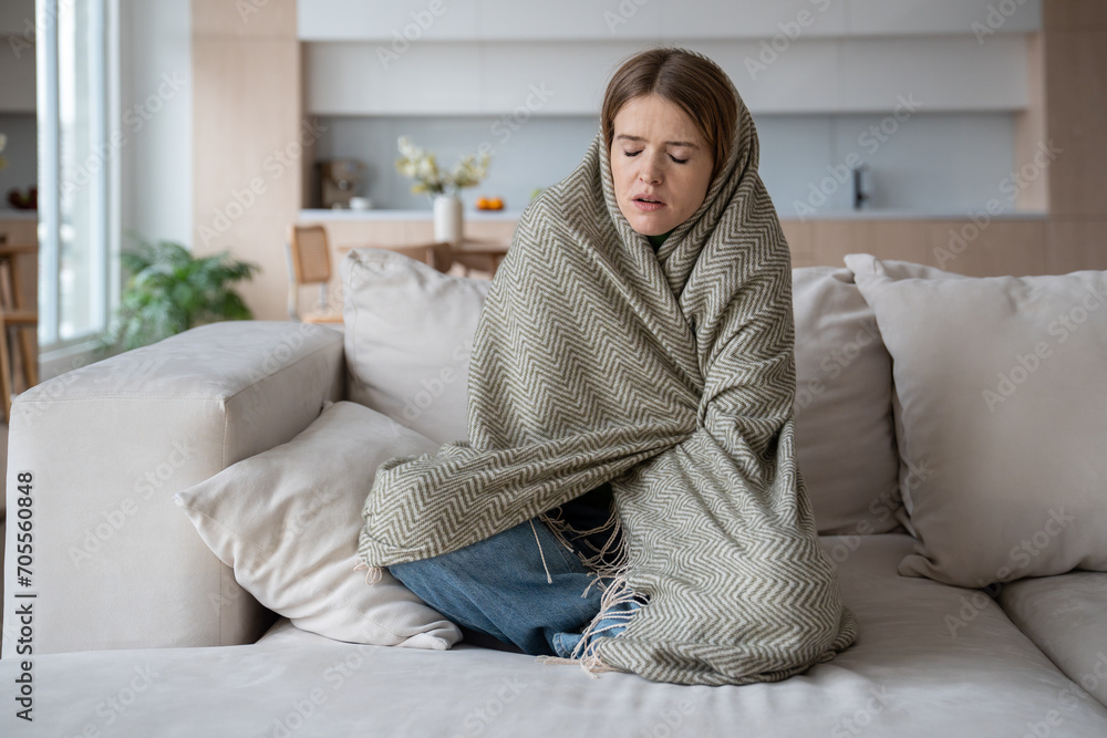 Depressed unhappy woman wrapping in plaid of cold, shivering, feeling ill, sick, having high temperature. Female suffering from symptoms of flu, inflammation, seasonal virus spending time at home Depressed unhappy woman wrapping in plaid of cold, shivering, feeling ill, sick, having high temperature. Female suffering from symptoms of flu, inflammation, seasonal virus spending time at home