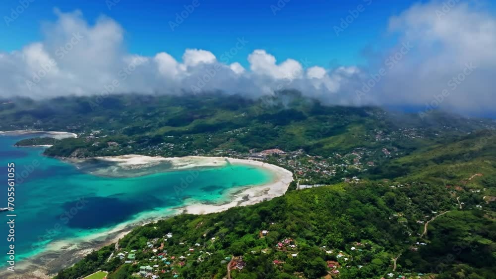 Aerial panoramic view of Mahè island in the Seychelles, Indian ocean. High view of the paradisiac turquoise ocean and the green lush vegetation. Bright blue sky, traveling clouds. Aerial panoramic view of Mahè island in the Seychelles, Indian ocean. High view of the paradisiac turquoise ocean and the green lush vegetation. Bright blue sky, traveling clouds.