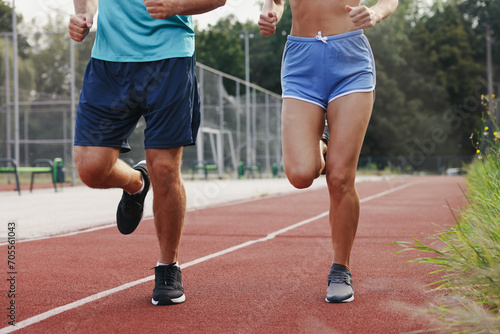 Healthy lifestyle. Sporty couple running at stadium, closeup