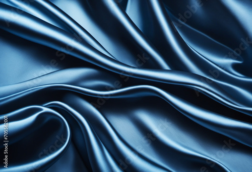 Abstract blue black background. Blue silk satin texture background. Beautiful soft wavy folds on shiny fabric. Dark elegant background for your design.