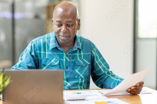 Business senior man 60 years old using laptop computer in office. Happy middle aged man, entrepreneur, small business owner working online.
