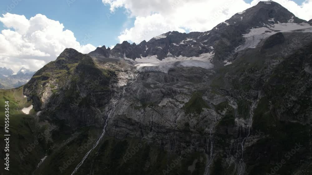 A gorgeous waterfall flows down in many streams from a mountain glacier A gorgeous waterfall flows down in many streams from a mountain glacier