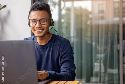 close up call center indian man wear headset and smiling while working in office with service-mind for hotline telemarketing and helpdesk agent 24/7 support concept photo