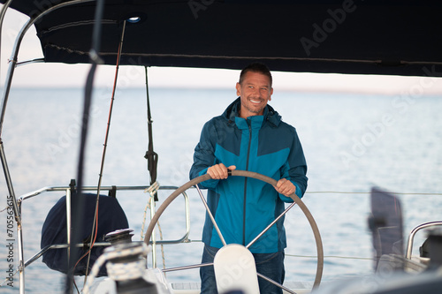 Smiling mature man sailing a ship
