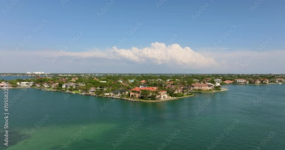 Expensive mansions between green palm trees on Gulf of Mexico shore in Sarasota city in Florida, USA. Aerial view of wealthy waterfront neighborhood. Premium housing development Expensive mansions between green palm trees on Gulf of Mexico shore in Sarasota city in Florida, USA. Aerial view of wealthy waterfront neighborhood. Premium housing development
