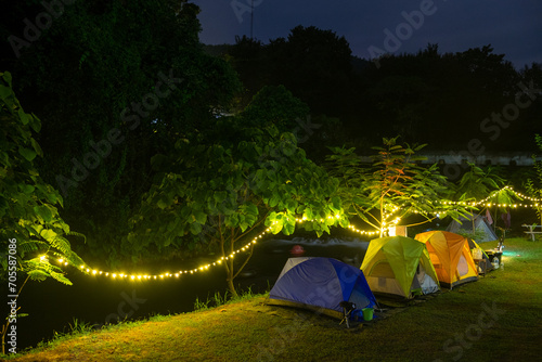 tents in the forest at night with a mountain in the background