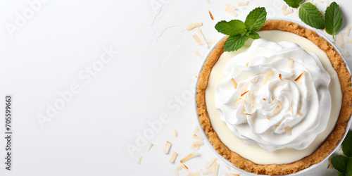 Top view of coconut cream pie garnished with mint leaves on white background with copy space Delicious fresh baked healthy dessert photo
