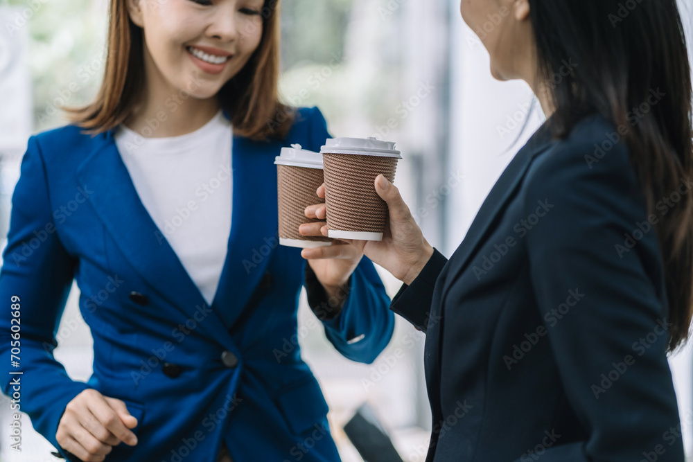 female colleague of half Asian descent holds a cup of coffee and smiles happily. female colleague of half Asian descent holds a cup of coffee and smiles happily.