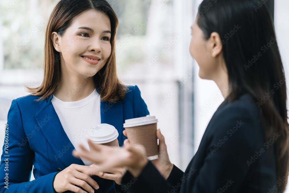 female colleague of half Asian descent holds a cup of coffee and smiles happily. female colleague of half Asian descent holds a cup of coffee and smiles happily.