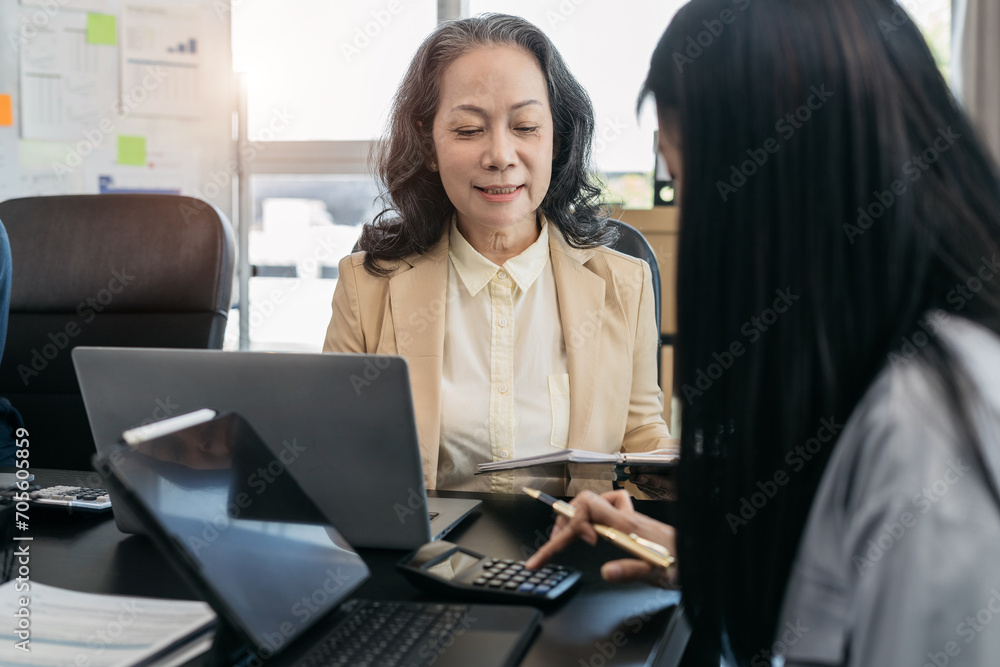 Business team using a calculator to calculate the numbers of statistic business profits growth rate on documents graph data, desk in the office. Business team using a calculator to calculate the numbers of statistic business profits growth rate on documents graph data, desk in the office.