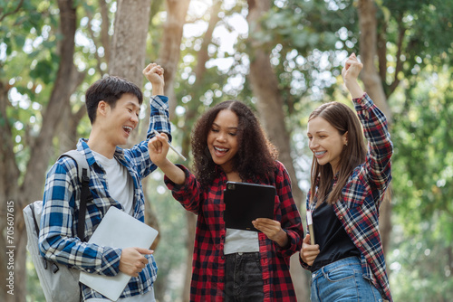 Happy group of college students use laptop feel excited overjoyed with good news over smartphone or Tablet.