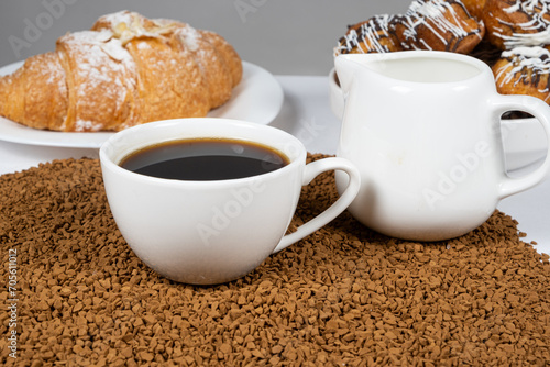 Fototapeta Naklejka Na Ścianę i Meble -  A cup of hot instant coffee on a background of freeze-dried granules